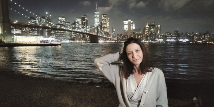 Lory, autrice di NewYorkFacile.it, sorride con lo skyline notturno di New York alle sue spalle da Pebble Beach.