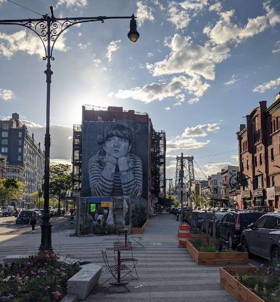 Murales a Williamsburg, con il ponte sullo sfondo in una giornata soleggiata